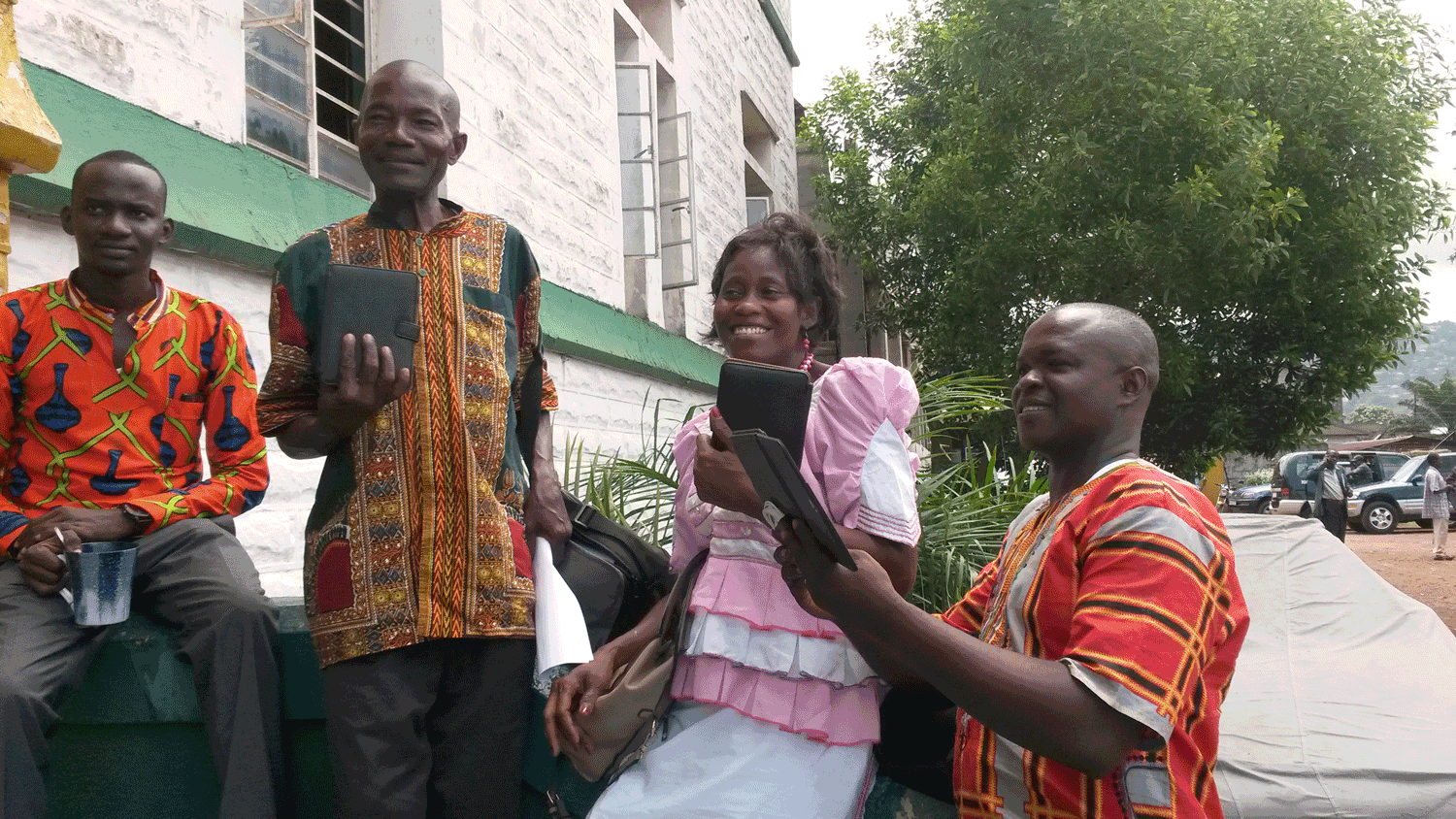 Vicctor Kallon, Anthonette Singbeh, and Patrick Vandi pose with their e-readers