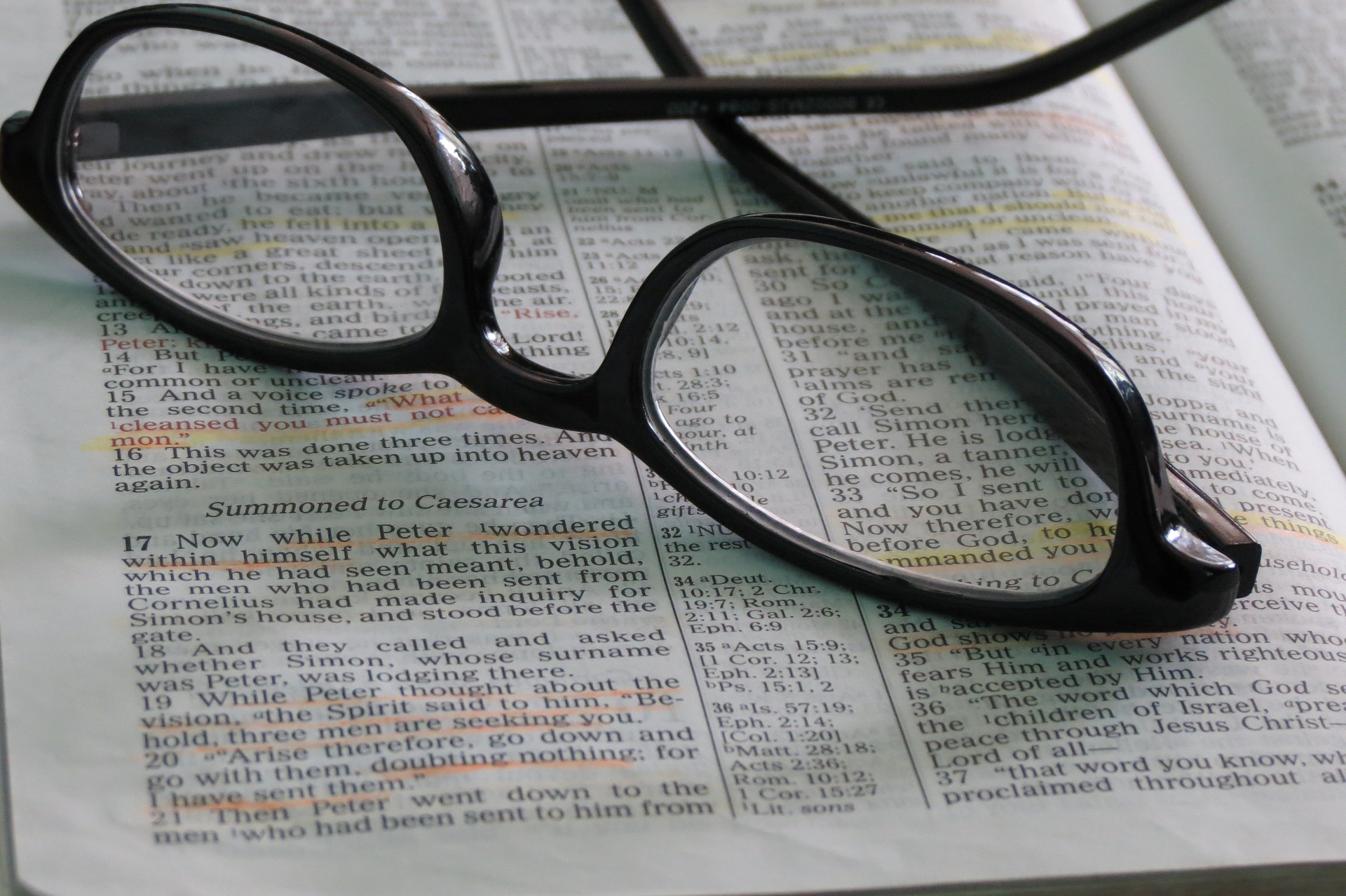 Reading glasses resting on open Bible